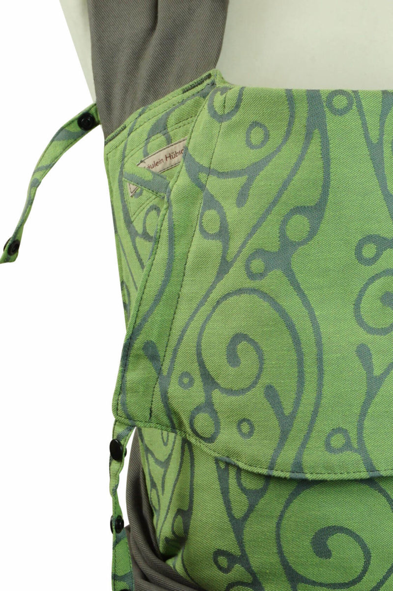 Babytrage in Lindgrün mit geschwungenem, grauen Muster und dunkelgrauen Trägern