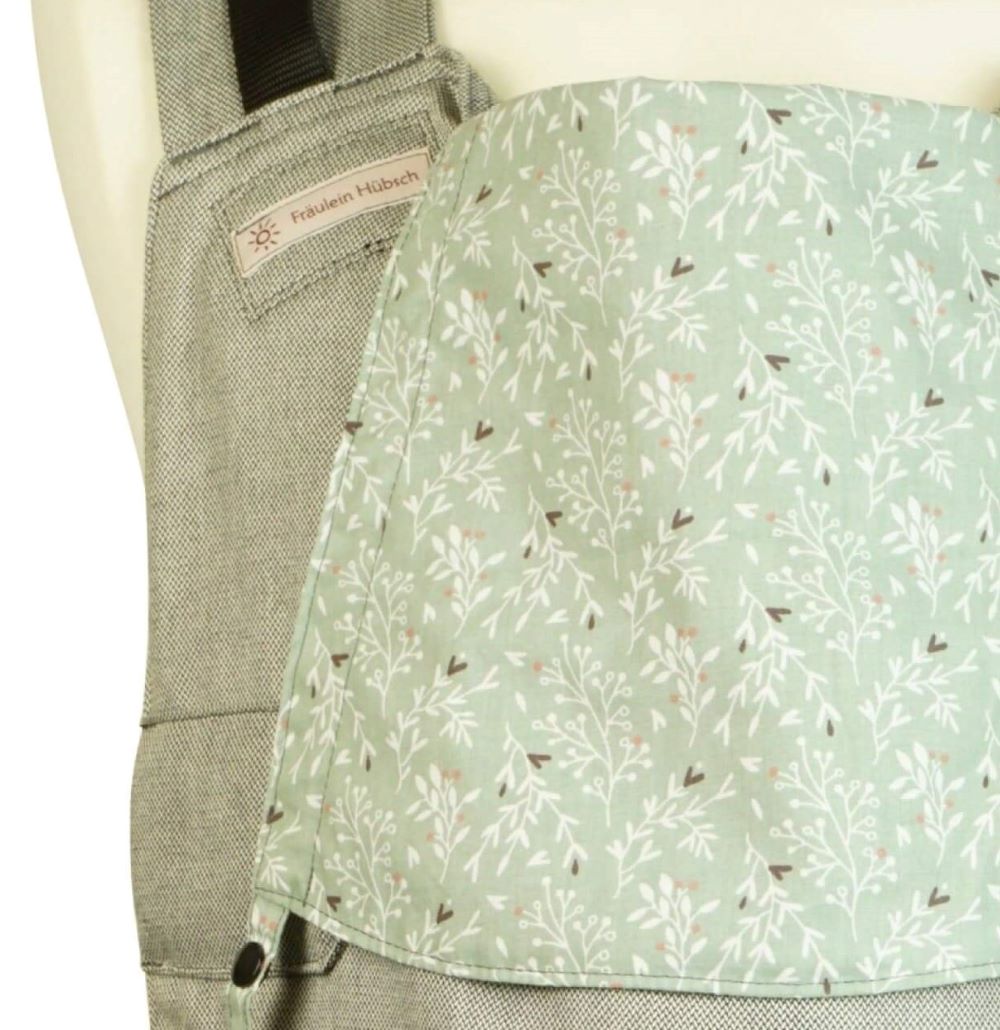 Rucksack Babytrage Fullbuckle von Fräulein Hübsch. Hellgrauer Stoff mit einer Kopfstütze aus salbeigrünem Baumwollstoff mit zarten weißen Zweigen und kleinen schwarzen Herzen und altrosa Pünktchen.