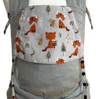Hellgraue Babytrage mit Kopfstütze aus Dekostoff. Auf grauem Hintergrund sind orangebraune sitzende Füchse, Bäume und Hasen abgebildet.