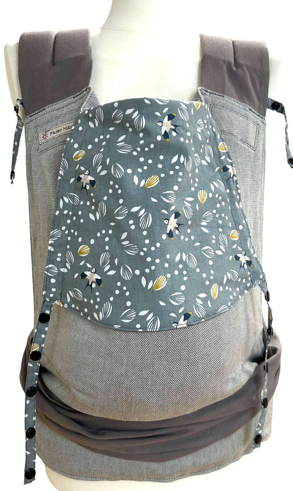 Mei Tai Toddlersize Schwalben Frontal Fräulein Hübsch Mei Tai Babytrage in Hellgrau mit grauen Schulterträgern und Bauchgurt. Die Kopfstütze ist aus salbeigrünem Stoff mit kleinen schwalben und weißen Zweigen.