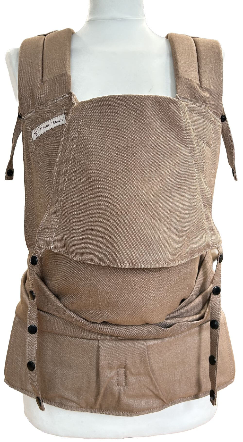 SoftTai V2 Babysize Toffee Frontal Babytrage von Fräulein Hübsch in hellem Toffee-Braun auf einer SChneiderpuppe in seitlicher Ansicht. Der Hüftgurt schließt mit Schnalle, die Schulterträger sind zu binden.