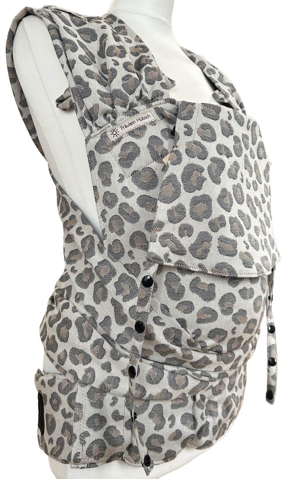 WrapCon Babysize Leoprint Seitlich Babytrage WrapCon von Fräulein Hübsch in Leoprint in schwarz und braun auf hellem Grund. Die Träger sind auffächerbar und zum verknoten, der Bauchgurt schließt mit einer Schnalle.