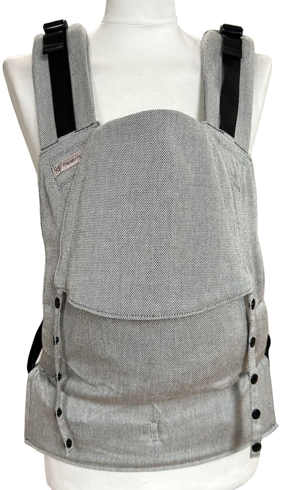 Fullbuckle Rucksacktrage Größe Newborn in der Farbe Silver auf einer Schneiderbüste. Alle Gurte schließen mit SChnallen wie bei einem Rucksack, kein Binden.