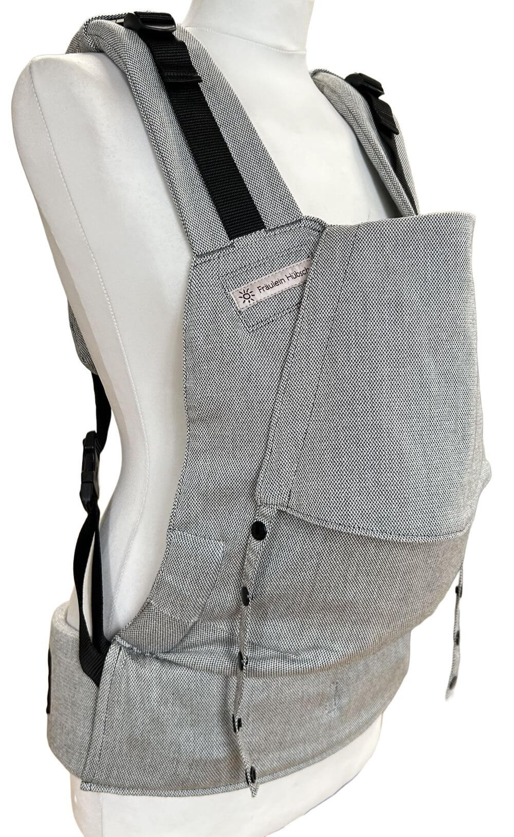 Fullbuckle Rucksacktrage Größe Newborn in der Farbe Silver auf einer Schneiderbüste. Alle Gurte schließen mit SChnallen wie bei einem Rucksack, kein Binden.