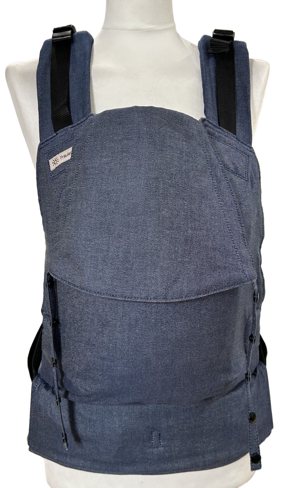 Fullbuckle Newborn Denim Frontal Fullbuckle Rucksacktrage Größe Newborn in der Farbe Denim auf einer Schneiderbüste. Alle Gurte schließen mit Schnallen wie bei einem Rucksack, kein Binden.