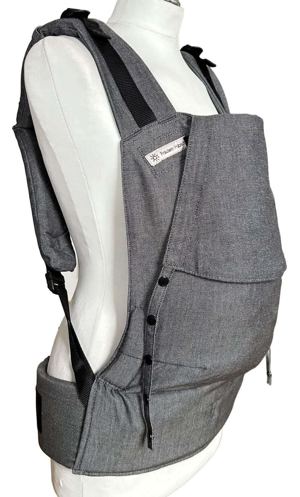 Fullbuckle Newborn Graphite seitlich Fullbuckle Rucksacktrage Größe Newborn in der Farbe Graphite auf einer Schneiderbüste. Alle Gurte schließen mit Schnallen wie bei einem Rucksack, kein Binden.