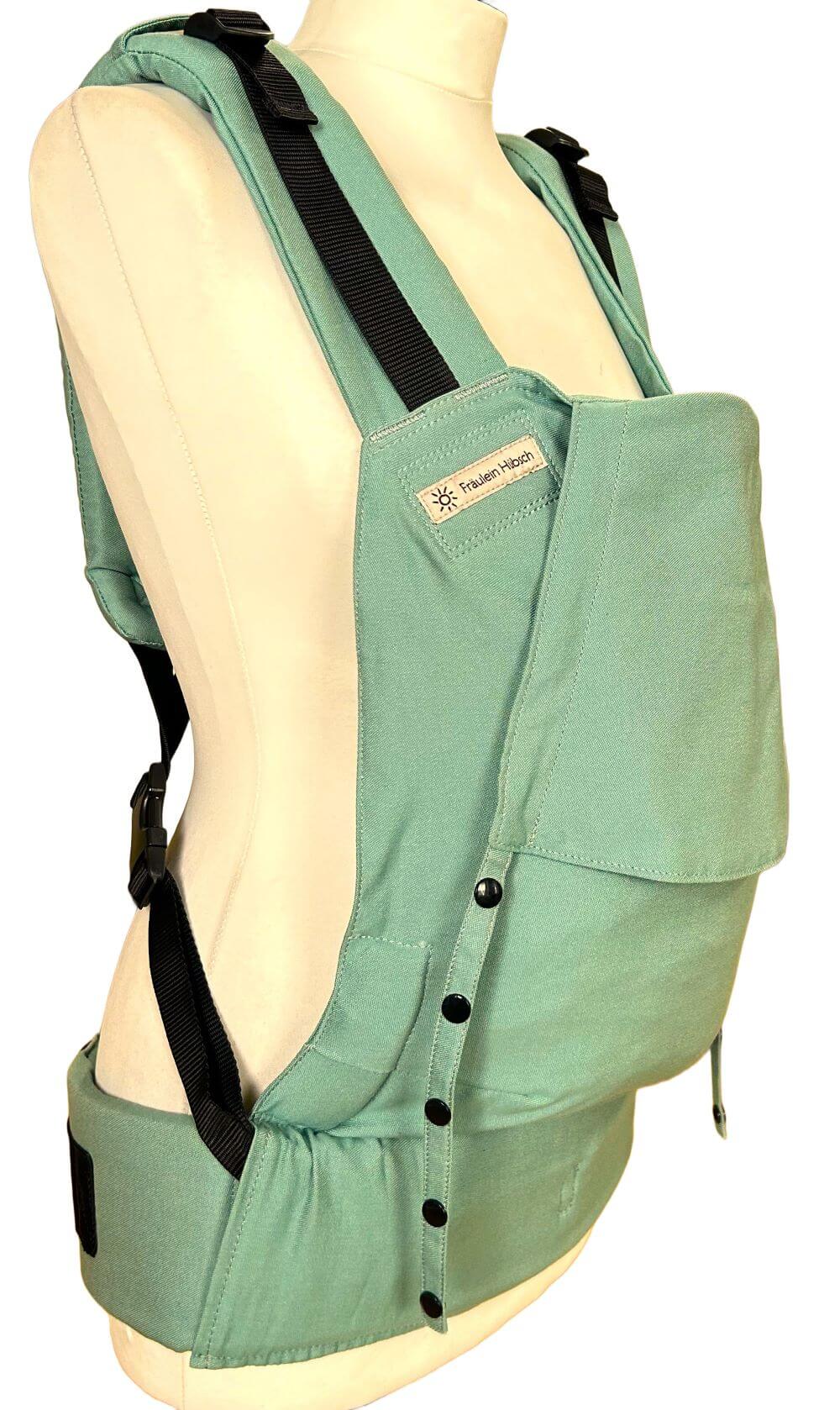 Fullbuckle Newborn Jade seitlich Fullbuckle Rucksacktrage Größe Newborn in der Farbe Jade auf einer Schneiderbüste. Alle Gurte schließen mit Schnallen wie bei einem Rucksack, kein Binden.