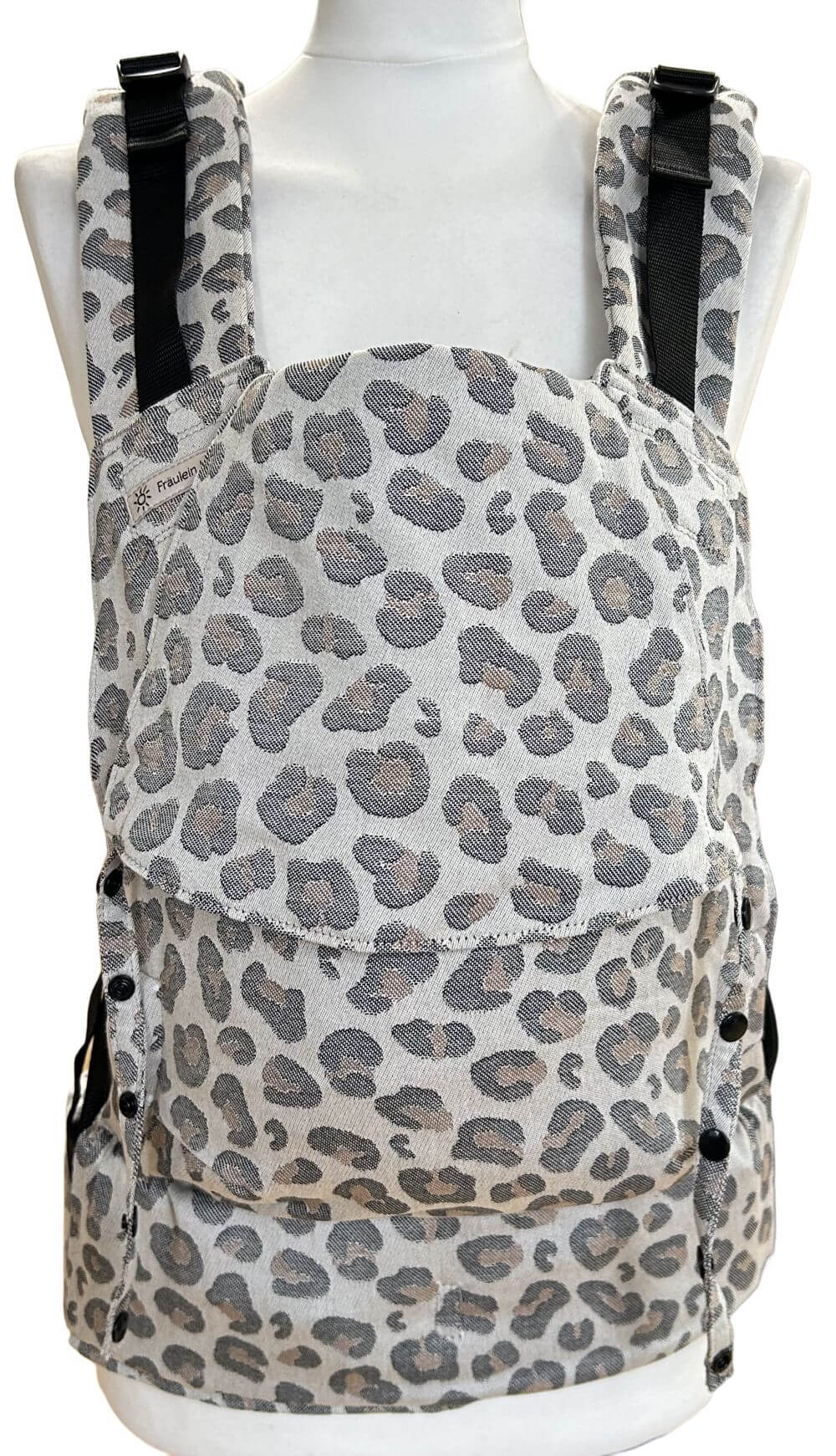 Fullbuckle Newborn Leoprint frontal Fullbuckle Rucksacktrage Größe Newborn in der Farbe Leoprint auf einer Schneiderbüste. Alle Gurte schließen mit Schnallen wie bei einem Rucksack, kein Binden.