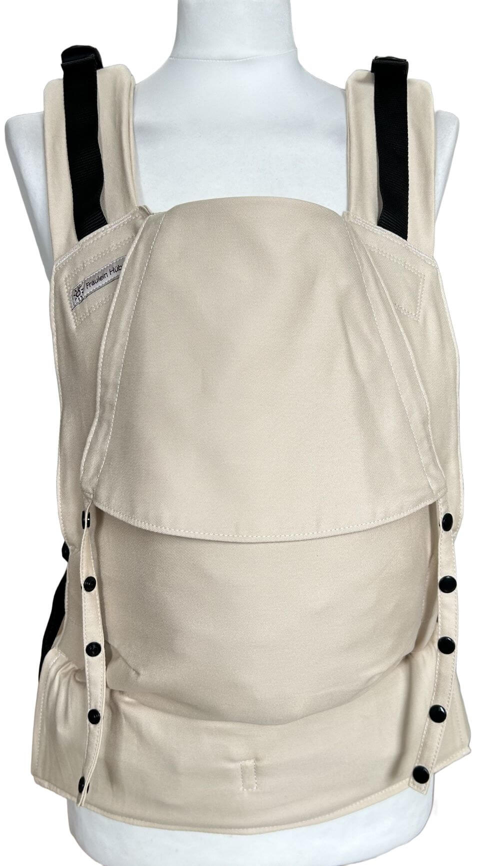 Fullbuckle Rucksacktrage Größe Newborn in der Farbe Sand auf einer Schneiderbüste. Alle Gurte schließen mit Schnallen wie bei einem Rucksack, kein Binden.