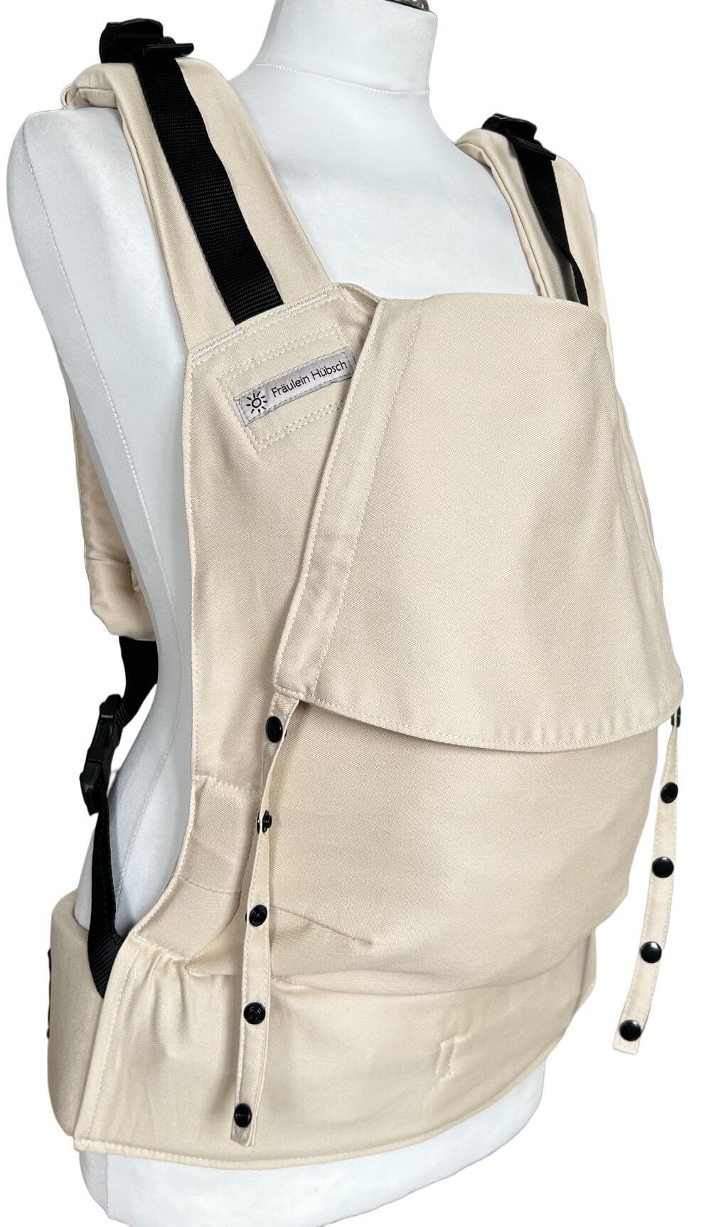 Fullbuckle Rucksacktrage Größe Newborn in der Farbe Sand auf einer Schneiderbüste. Alle Gurte schließen mit Schnallen wie bei einem Rucksack, kein Binden.