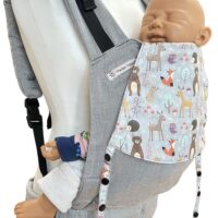 Fräulein Hübsch Fullbuckle Newborn in Hellgrau mit bunter Kopfstütze, auf der bunte Waldtiere auf hellgrauem Grund abgebildet sind. Die Trage wird auf einer Schneiderpuppe gezeigt.