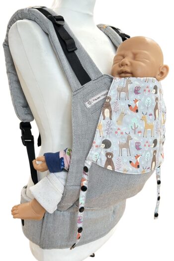 Fräulein Hübsch Fullbuckle Newborn in Hellgrau mit bunter Kopfstütze, auf der bunte Waldtiere auf hellgrauem Grund abgebildet sind. Die Trage wird auf einer Schneiderpuppe gezeigt.