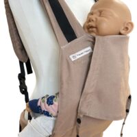 Fullbuckle Rucksacktrage Größe Newborn in der Farbe Toffee auf einer Schneiderbüste. In der Trage sitzt eine Puppe. Alle Gurte schließen mit Schnallen wie bei einem Rucksack, kein Binden.