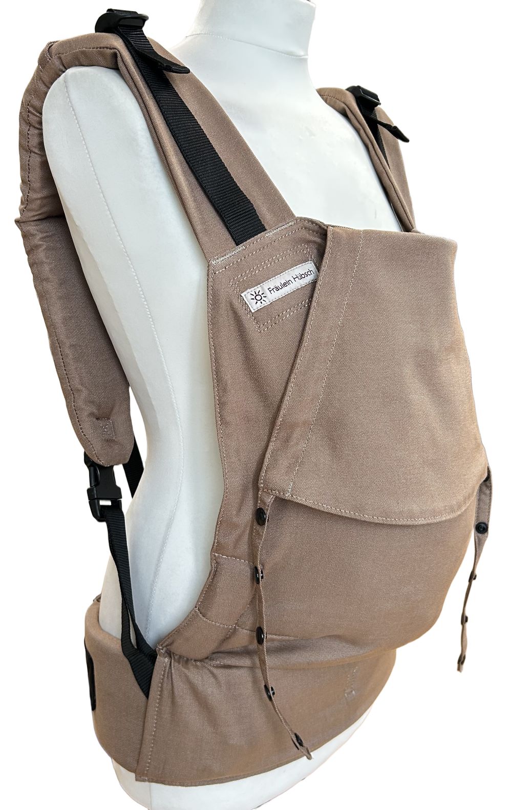 Fullbuckle Rucksacktrage Größe Newborn in der Farbe Toffee auf einer Schneiderbüste. Alle Gurt schließen mit Schnallen wie bei einem Rucksack, kein Binden