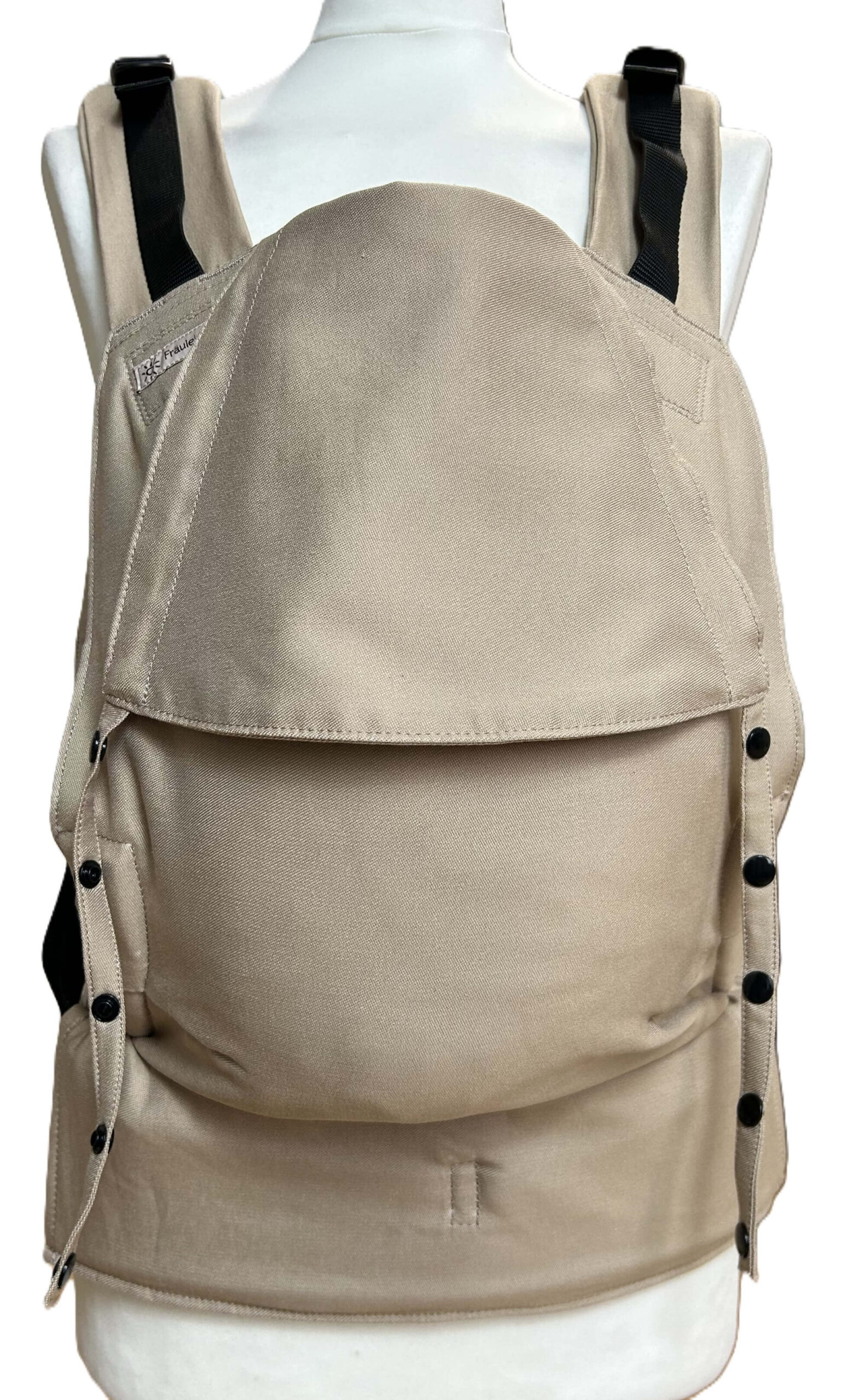 Fullbuckle Newborn Light Taupe frontal Fräulein Hübsch Fullbuckle Rucksacktrage Größe Newborn in der Farbe Light Taupe auf einer Schneiderbüste. Alle Gurte schließen mit Schnallen wie bei einem Rucksack, kein Binden.
