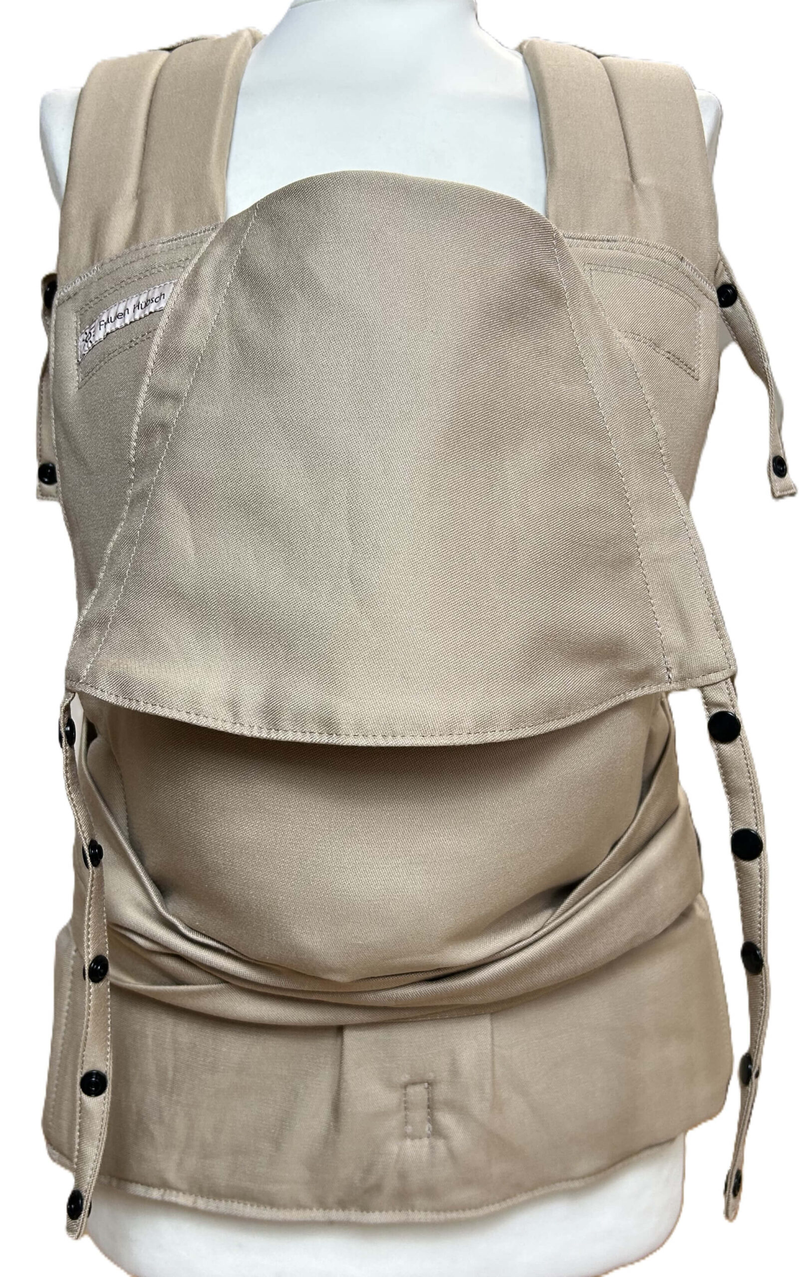 Fräulein Hübsch SoftTai Babysize in der Farbe Light Taupe. Die Trage wird in Vorderansicht auf einer Schneiderpuppe gezeigt.