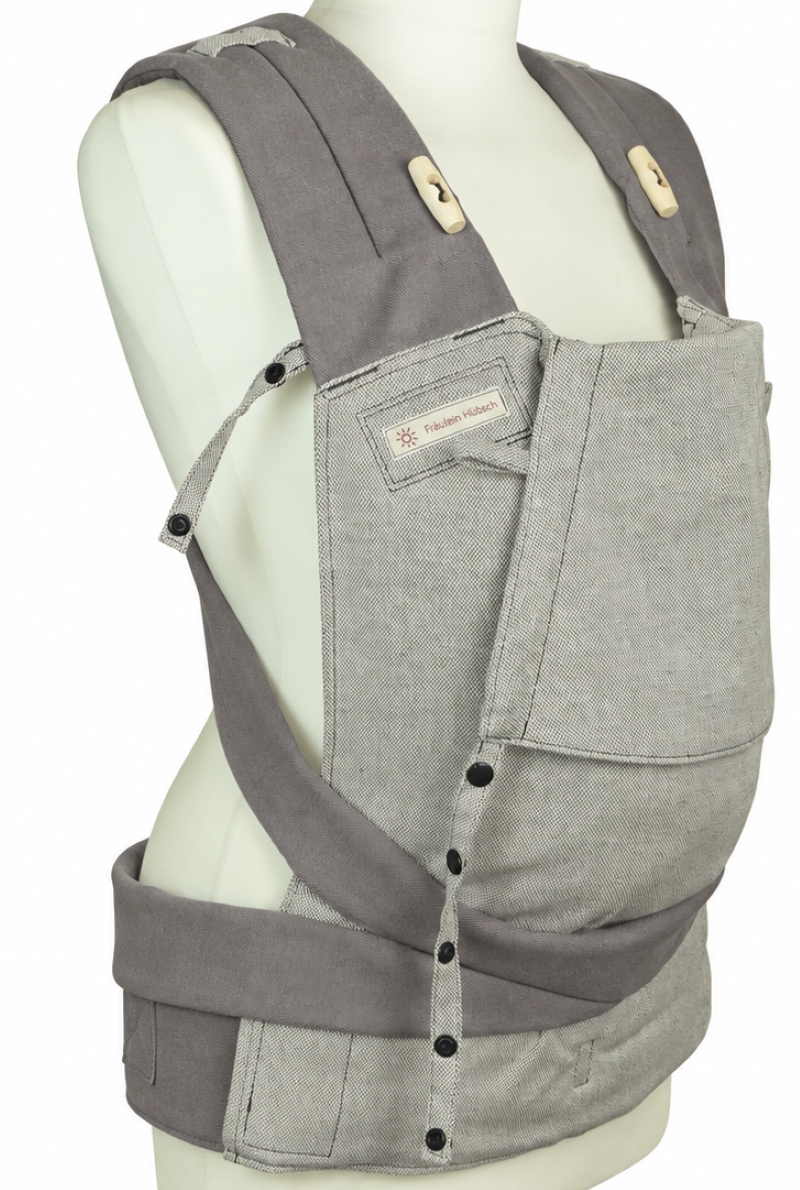 Ergonomische Babytrage Fräulein Hübsch Mei Tai mit grauen Trägern und hellgrauem Rückenteil auf Schneiderbüste, seitlich aufgenommen weißem Hintergrund.